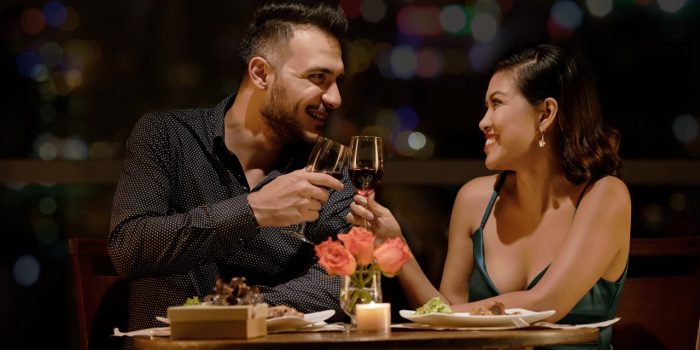 Couple toasting wine at romantic dinner.